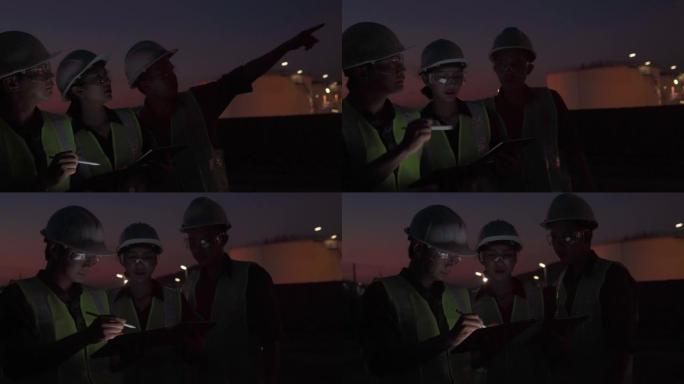 团队工程师或其他专业人员在石油和天然气或其他工业现场工作的视频，晚上使用数字平板电脑工作