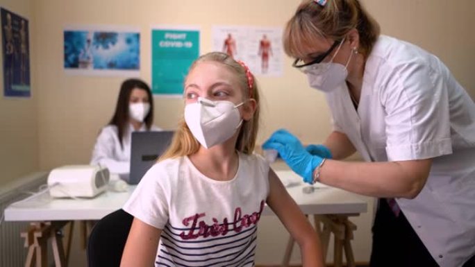 女医生在实验室给微笑的女孩接种新型冠状病毒肺炎疫苗