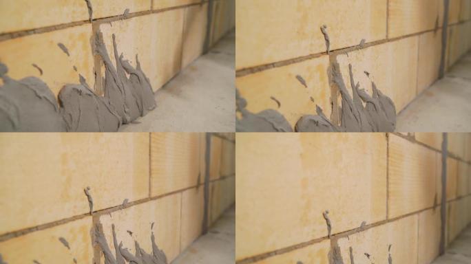一名工人在墙壁上涂灰泥并涂上水泥砂浆。把溶液涂在墙上。