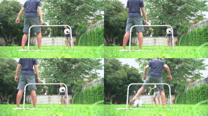 年轻的亚洲老大哥踢足球进行户外锻炼，周末在花园里与小弟弟一起休闲活动，低角度视角: 大男孩作为进球球