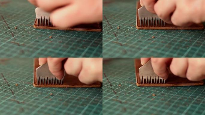 皮革持卡人的制造过程。用金属打孔器在皮革工件上打孔。手工皮革制品。爱好概念。