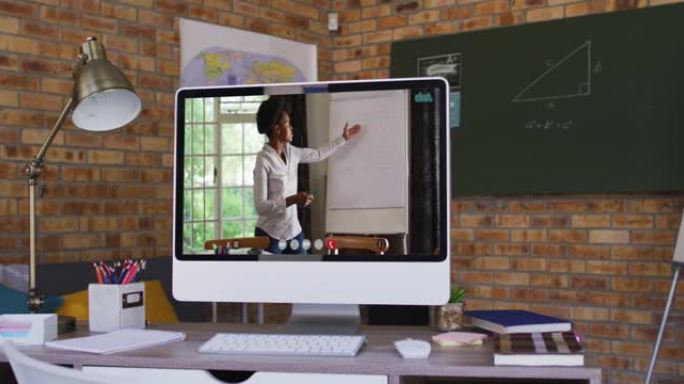 非裔美国女老师在学校桌子上的计算机上进行视频通话的网络摄像头视图