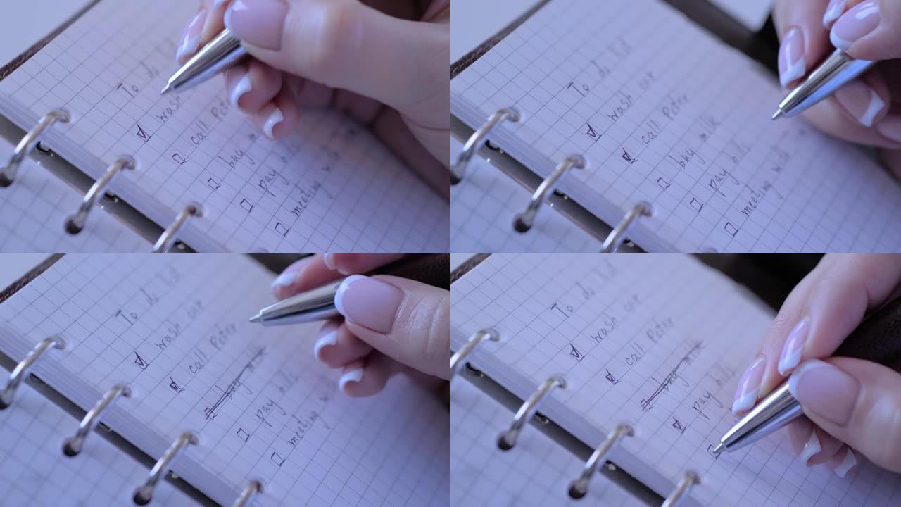 特写视图-女人在笔记本的待办事项清单复选框上打上标记