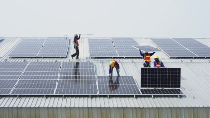 在屋顶上安装太阳能电池板的工人团队