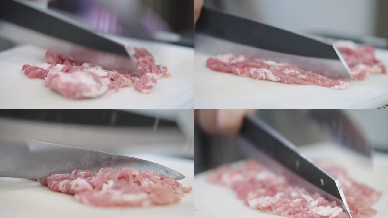 厨师用两把菜刀把猪肉切成小块。