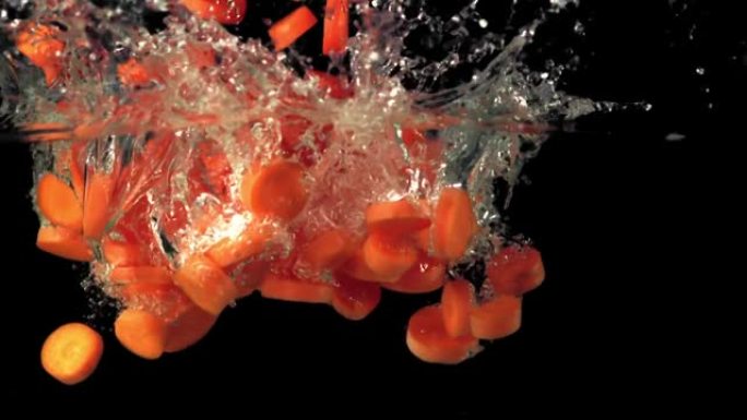 超级慢动作的胡萝卜碎片溅入水中。以1000 fps的高速相机拍摄。