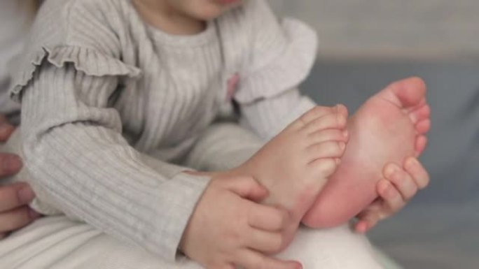可爱的好奇漂亮的小宝宝玩腿，数着脚趾，挠痒痒的脚