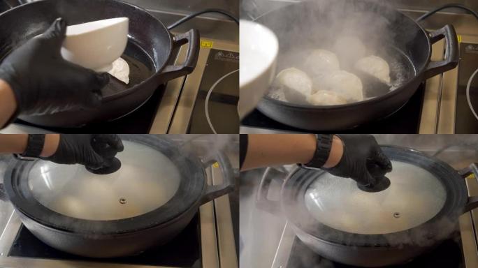 男厨师双手戴着黑手套在热煎锅上准备美味饺子的特写镜头