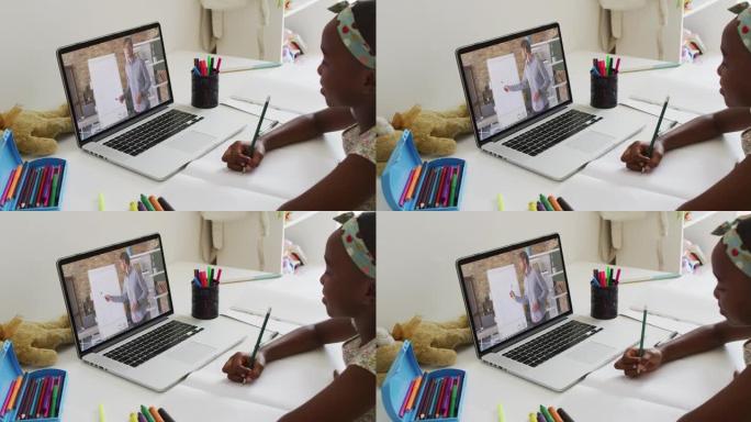 非裔美国女孩在家里用笔记本电脑与男老师进行视频通话时做作业
