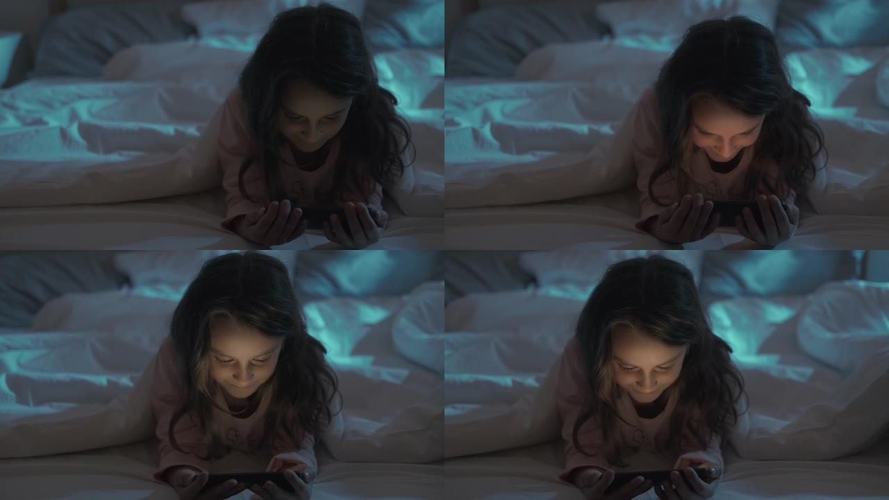 睡前电影儿童夜女孩在床上看电话