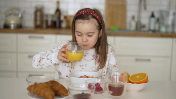 早餐时喝橙汁的健康孩子