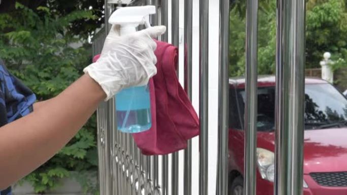 用手用湿巾和酒精消毒剂喷雾清洁不锈钢楼梯栏杆