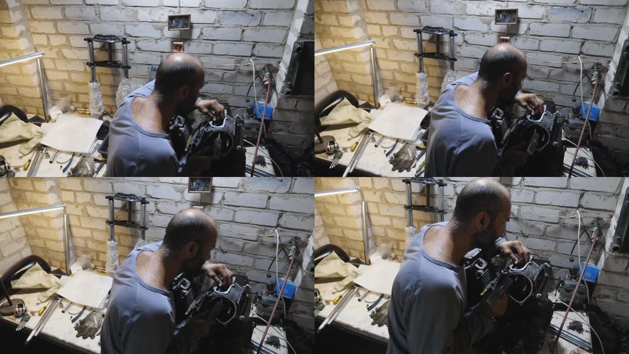 成人机械师在车库用锤子修理摩托车电机。男性修理工在工作场所工作。在车间工作的专业修理工。维护服务的概