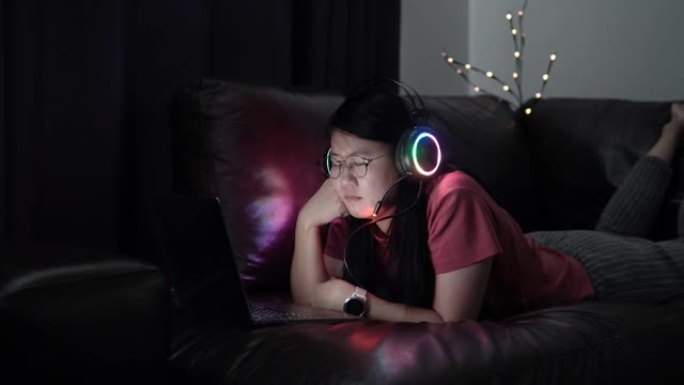 亚洲女性在家用笔记本电脑看电影。