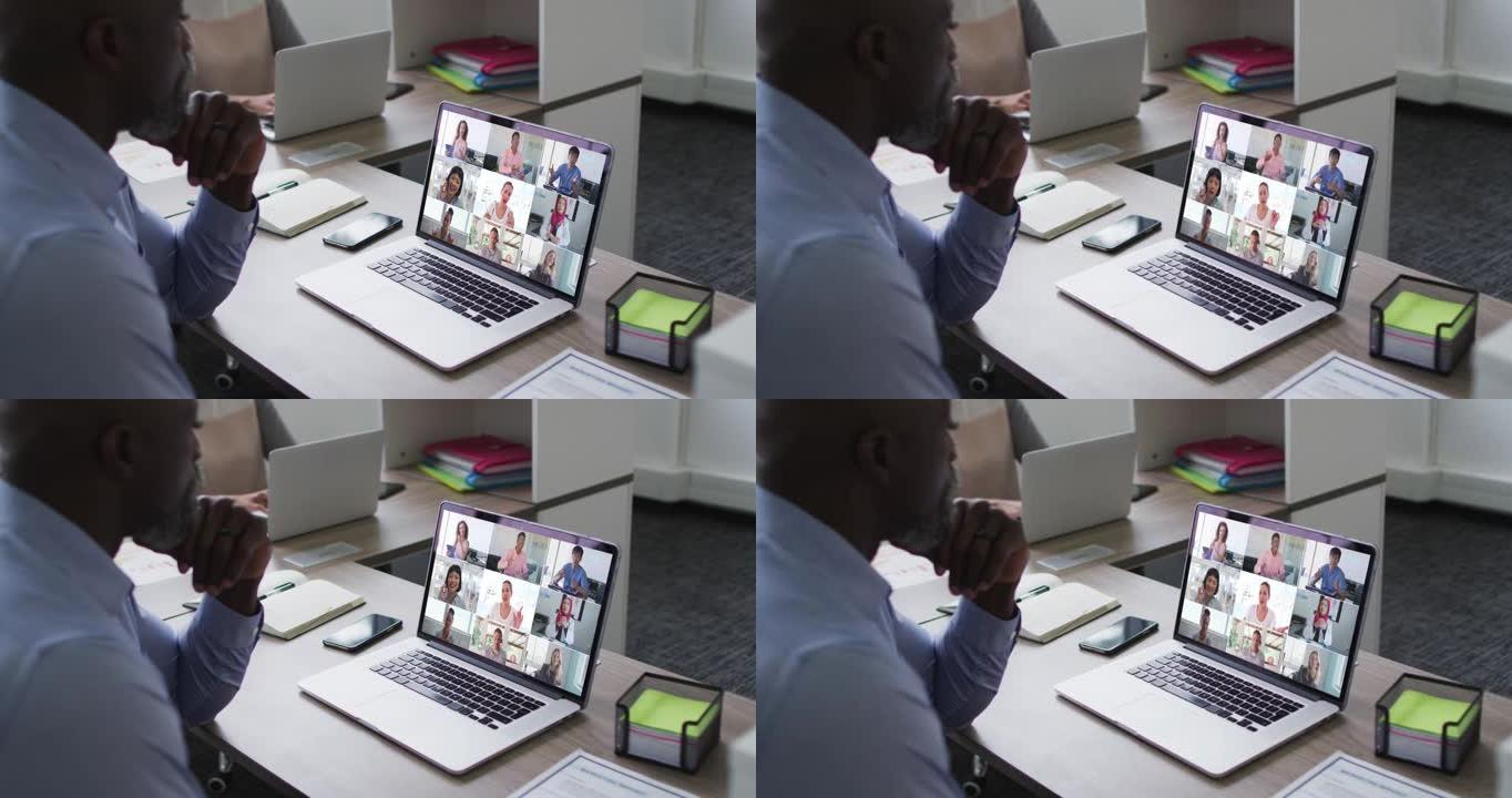 非裔美国高级男子在笔记本电脑上与办公室同事进行视频会议