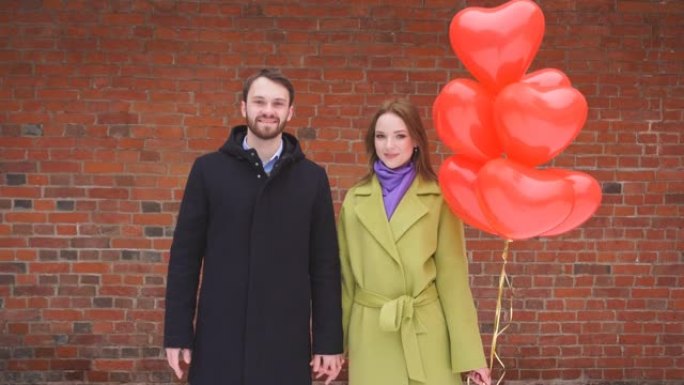 恋爱中的年轻夫妇约会，一个女人拿着很多气球