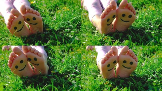 孩子的脚在草地上夏天画的微笑。选择性聚焦。孩子。