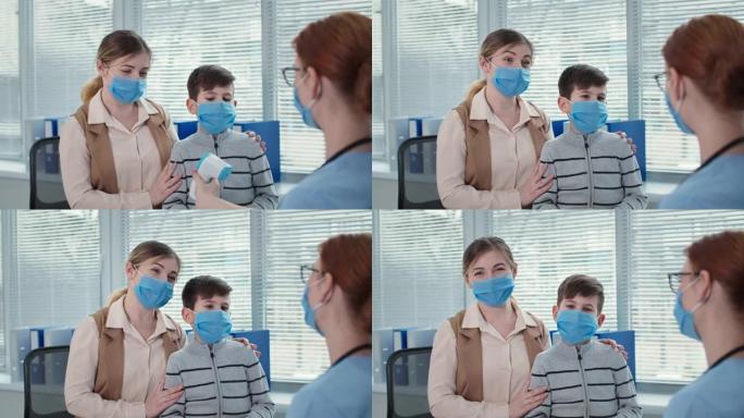 检疫期间的安全，医院戴着口罩的快乐男孩肖像，医生用非接触式温度计测量小病人的体温