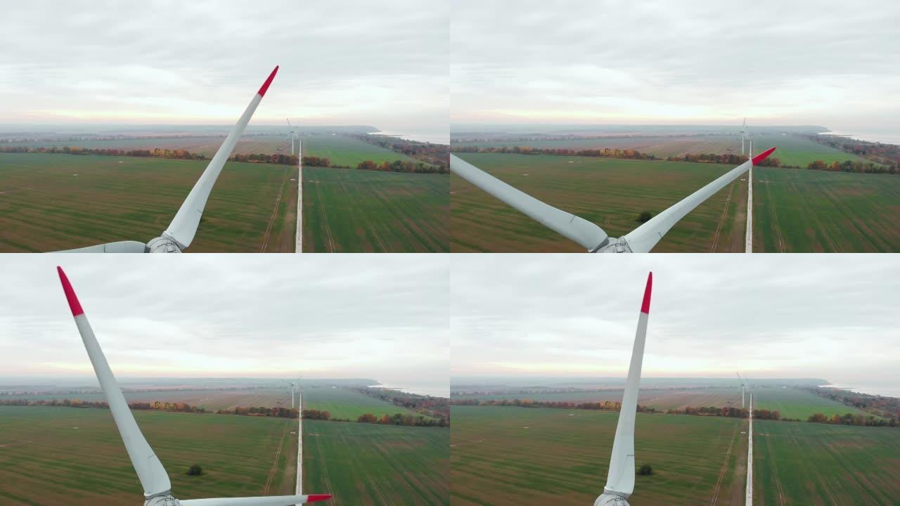 在美丽的日落秋景上旋转风力涡轮机。绿色生态发电能源。风力涡轮机农场生态场。野外风车上方的日出。鸟瞰图