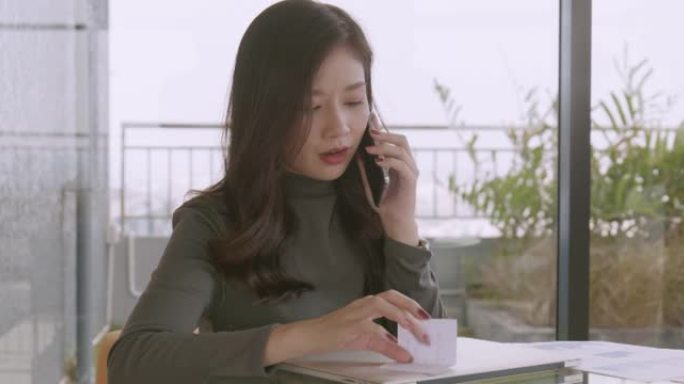 20-30岁的女性在休闲2016，视频聊天通过计算机电话会议在她家的客厅会见理财规划师。