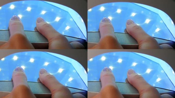 女人在紫外线下干燥拇指指甲上的基础凝胶