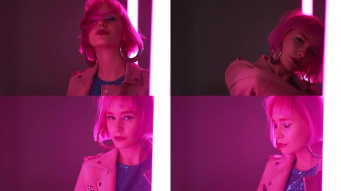 粉红色头发的惊人女人独自在发光二极管彩色明亮的灯之间跳舞。迷人的女士，夜生活的概念。现代流行服装，有