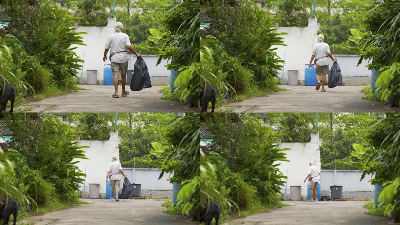 4k亚洲男子清理垃圾袋，然后放在离开他家的前面。