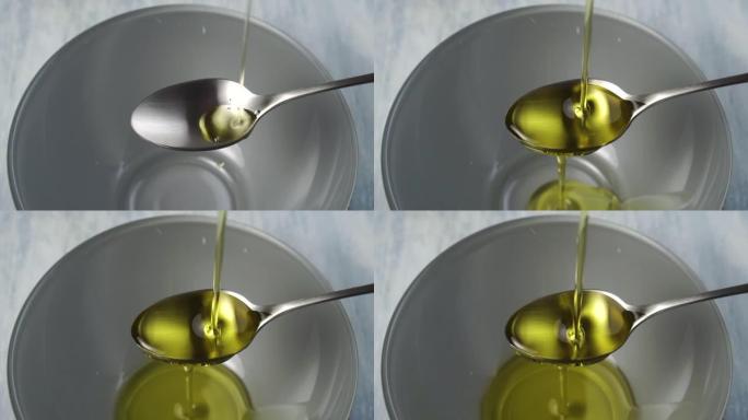 新鲜的植物油飞溅并溢出一茶匙，倒入一个灰色的碗中