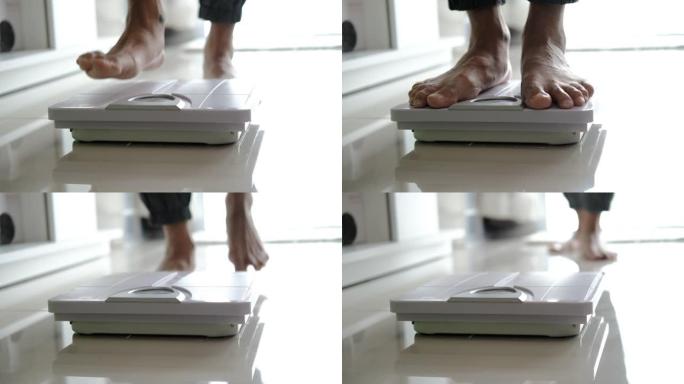 亚洲足部男子与体重体重秤，用于测量体重减轻。称重秤健康减肥概念。中长镜头平移娃娃移动焦点多莉滑块，用