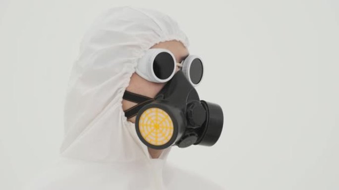 穿着防护服的人从自己身上脱下防毒面具的特写镜头。以白色背景拍摄。