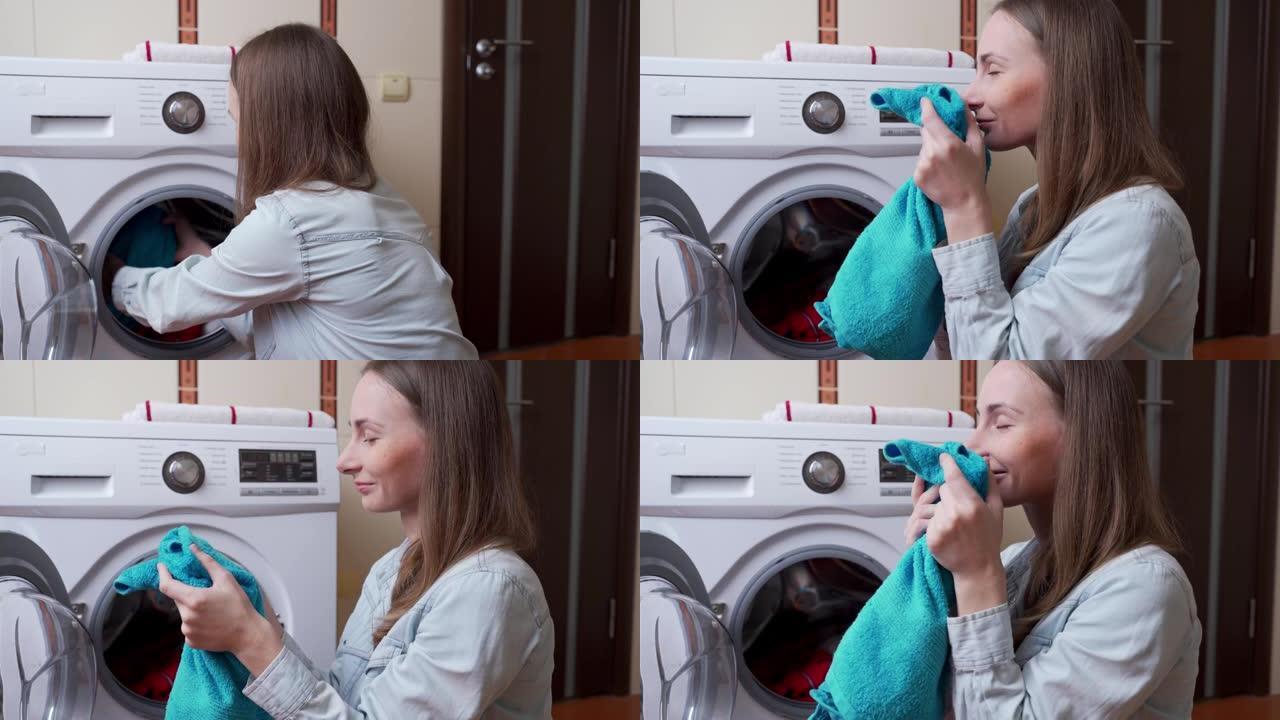 女人在洗衣机中洗涤后吸入新鲜干净毛巾的气味