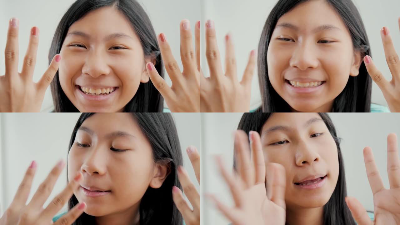 快乐的亚洲女孩在家里展示她画的指甲，生活方式的概念。