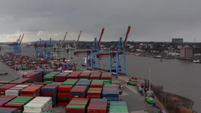 汉堡港河边货物起重机和彩色集装箱的低鸟瞰图