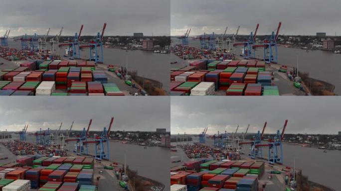 汉堡港河边货物起重机和彩色集装箱的低鸟瞰图