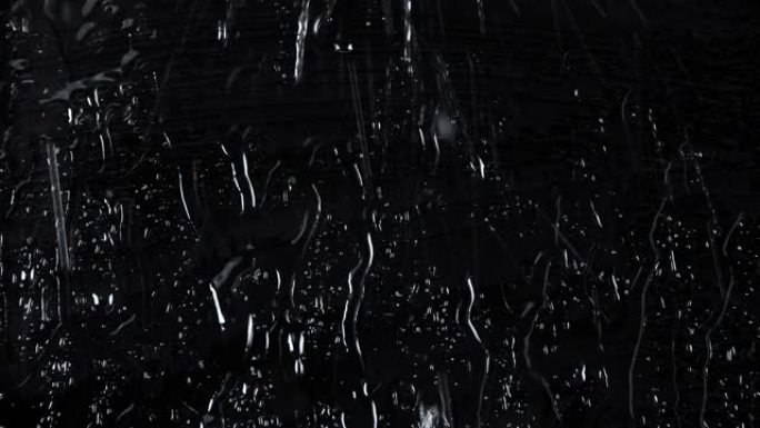 黑色玻璃背景上的水滴慢动作镜头