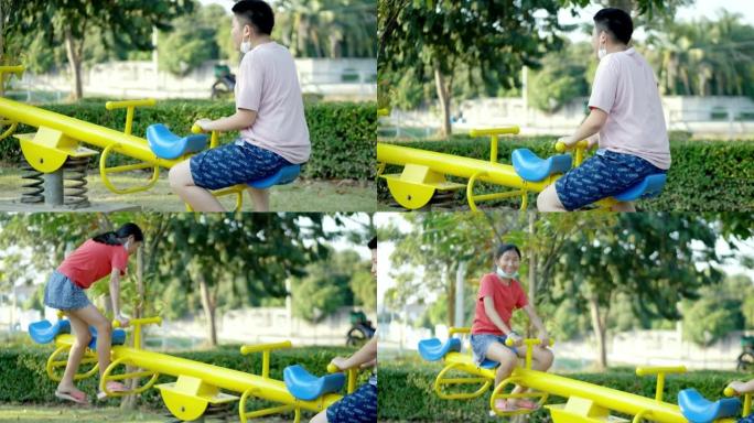 快乐的亚洲儿童在操场上一起玩跷跷板，生活方式理念。