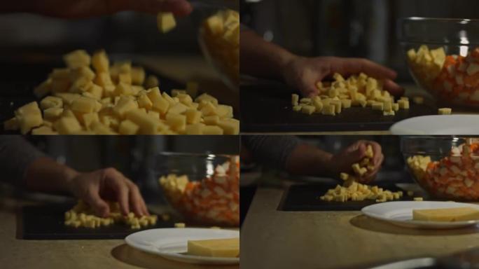 在切菜板上混合奶酪块。在家厨房准备蟹棒、奶酪、黄瓜、玉米罐头和鸡蛋沙拉