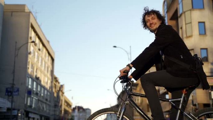 年轻商人上班时骑自行车的肖像-城市环境