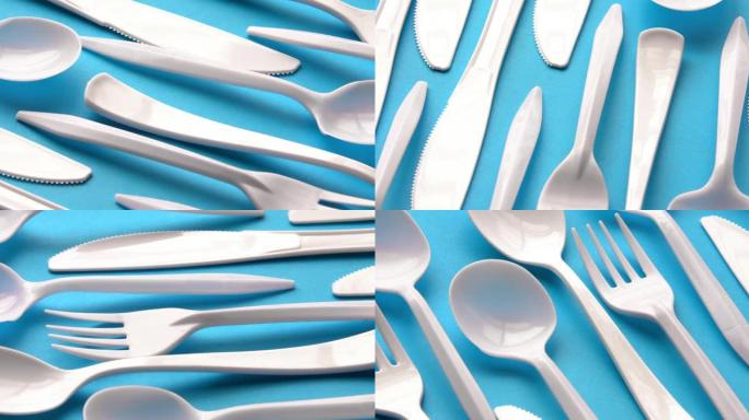 蓝色背景上的一次性白色塑料餐具。概念: 禁止一次性使用塑料。