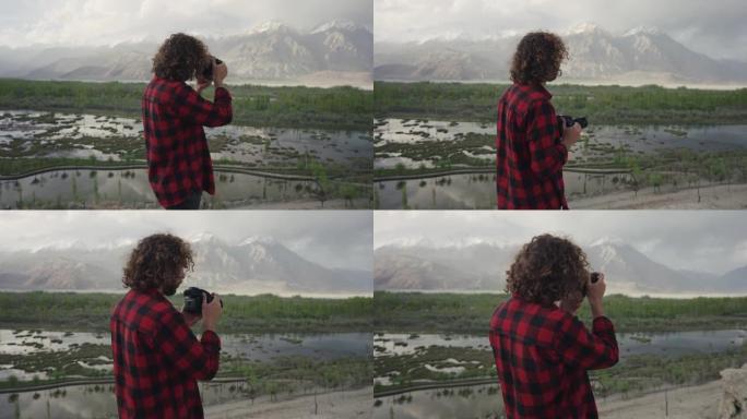 男子用相机拍摄巴基斯坦北部的河流和山脉