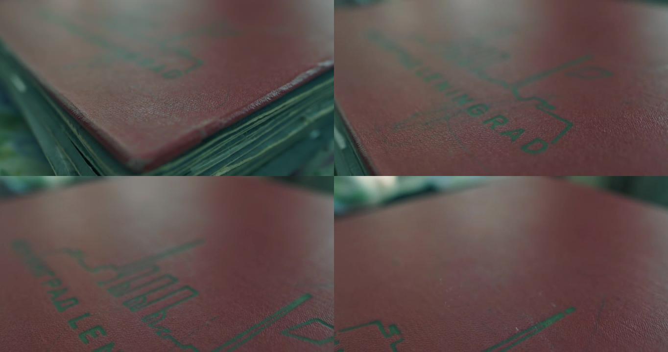 复古相册，刻有列宁格勒，红色。照相机沿着相册飞行。选择性聚焦