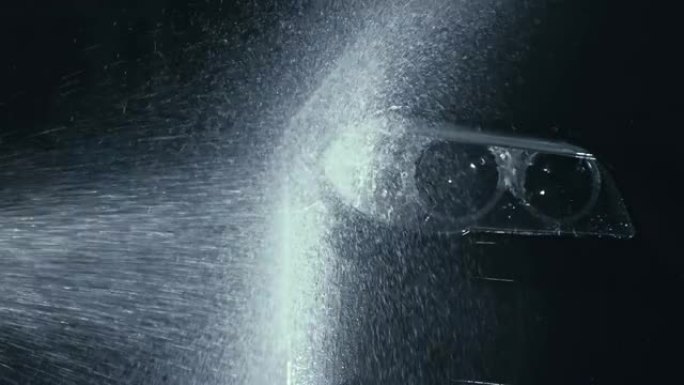 汽车前照灯清洗。用高压喷射清洗软管水清洗现代车身。汽车玻璃前照灯，滴眼液中的天使眼睛。