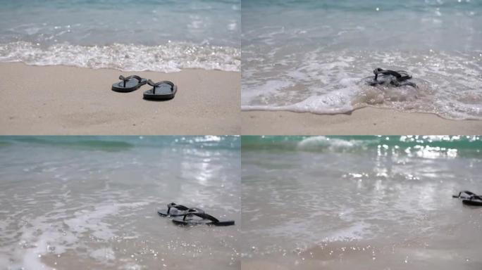 热带白色沙滩上的一双拖鞋和水浪的慢动作