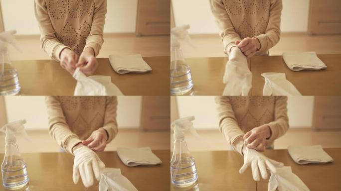 中年妇女戴着丁腈手套用酒精对客厅进行消毒。