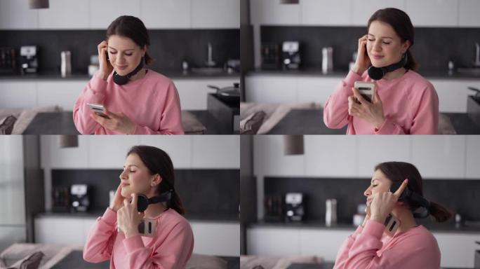 戴着耳机的漂亮年轻女子在厨房跳舞，听音乐