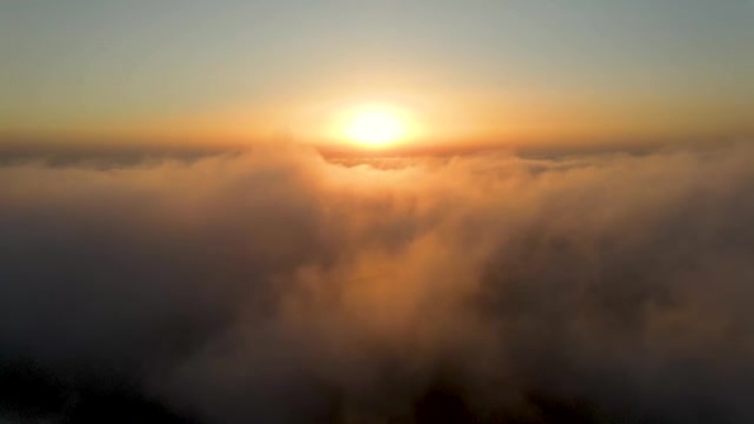 飞机的视点飞越蓬松的云层进入美丽的日落