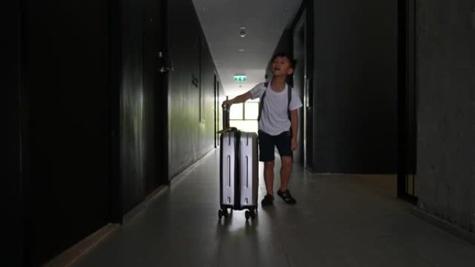 亚洲孩子在酒店提行李。旅游和度假的概念