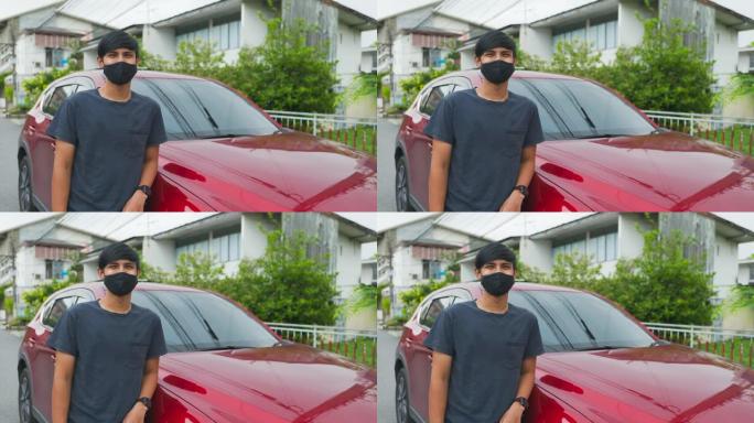 电影拍摄的快乐亚洲男子的肖像在车前，在面具脸后面微笑。