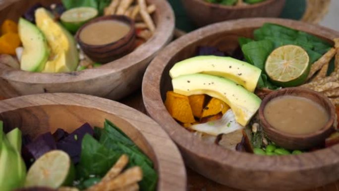 基于原始和乡村植物的午餐。蔬菜，叶子和鳄梨装在木碗中