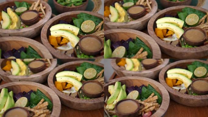 基于原始和乡村植物的午餐。蔬菜，叶子和鳄梨装在木碗中